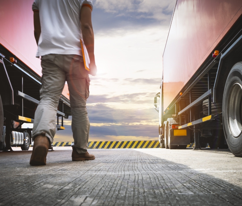 semi-trailer-trucks-parked-with-sunset-sky-truck-driver-is-checking-the-semi-truck-s-maintenance